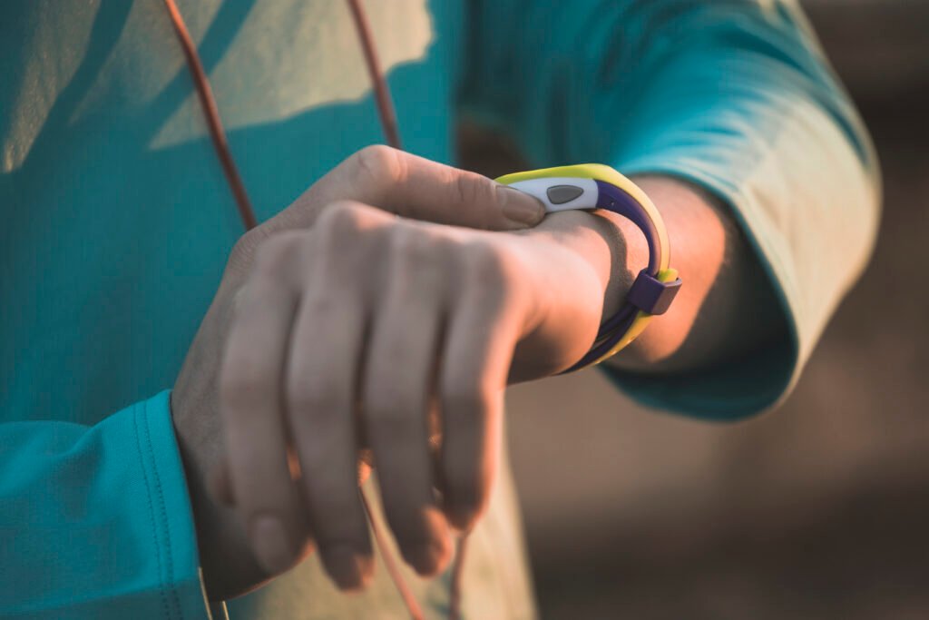 Primer plano de un atleta ajustando su reloj deportivo para medir ritmo cardíaco y desempeño en carrera